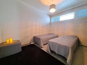 Una habitación con dos camas y una mesa y una ventana. en Timantti B13, en Kalajoki