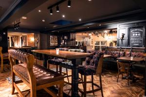 a bar with a wooden table and chairs at The Stanneylands in Wilmslow