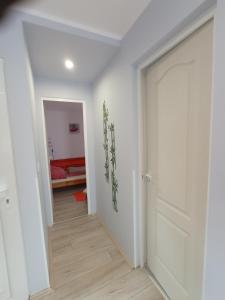 a hallway with a white door and a bedroom at Fagoda-Fogadó Vendégház in Orfű