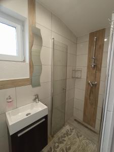 a bathroom with a sink and a shower at Fagoda-Fogadó Vendégház in Orfű