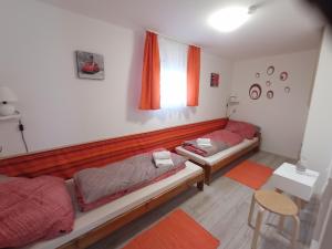 a bedroom with two beds and a table and a chair at Fagoda-Fogadó Vendégház in Orfű