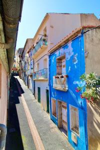 a blue and white building on a street at Grand studio sur la Marine in Sète