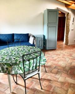 a living room with a table and a blue couch at Agriturismo Cervano in Toscolano Maderno