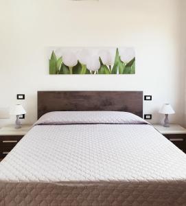 sypialnia z białym łóżkiem z 2 lampami w obiekcie Villini Cortesas w mieście Orosei