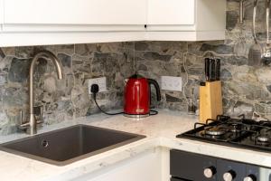 Boyne View House في تريم: طاولة مطبخ مع غلاية شاي احمر على موقد