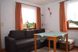ein Wohnzimmer mit einem Sofa und einem Tisch in der Unterkunft Ferienhaus Kohlmeise in Neudorf
