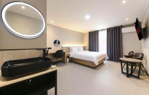 een hotelkamer met een bed en een spiegel bij LABE Hotel in Jeonju