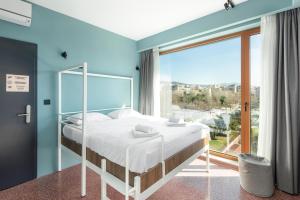 una camera da letto con un letto e una grande finestra di Zeus is Loose Hostel a Salonicco
