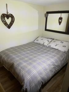 a bed in a room with a heart hanging on the wall at Deer Lodge in Thornton Curtis