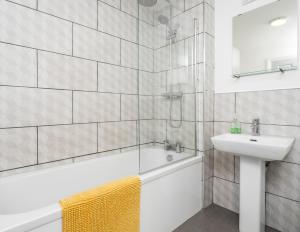Apex Living NE - Beachville House II 4 Beds FREE PARKING في سندرلاند: حمام مع حوض استحمام ومغسلة