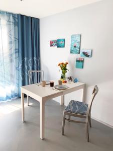uma mesa branca e uma cadeira com uma mesa branca e uma janela em SeeSucht-Apartment No86 mit Terrassen, Sauna & Pool em Bodman-Ludwigshafen