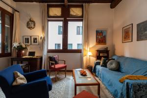 a living room with a blue couch and a table at Cà Paola Cozy Venice Apartment in Venice