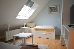 ein kleines Schlafzimmer mit einem Bett und einem Dachfenster in der Unterkunft Gästehaus Windheim (Karlsruhe-Knielingen) in Karlsruhe