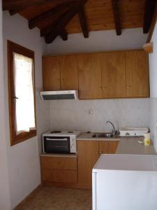 uma cozinha com armários de madeira e um forno com placa de fogão em Ourania Sea Breath em Punta