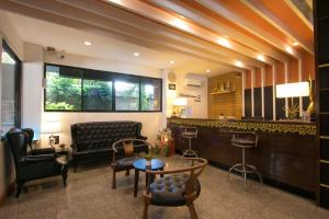 a lobby with a couch and a table and chairs at Sudyod Apartment in Bangkok