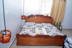 a bedroom with a wooden bed with a wooden frame at URUGANO VIRUNGA PALACE in Nyarugina