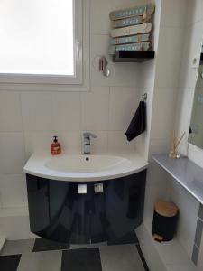 baño con lavabo blanco y ventana en Welcome en Nantes