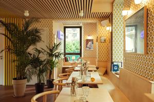a row of tables in a restaurant with plants at Cosmiques Hotel - Centre Chamonix in Chamonix-Mont-Blanc