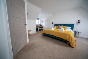 a bedroom with a bed with a yellow blanket on it at The Coffee Loft in Padstow