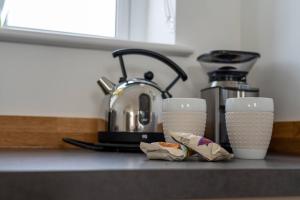 a kitchen counter with two cups and a sink at The Coffee Loft in Padstow