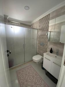 a bathroom with a shower and a toilet and a sink at CEYLANHOUSE Airportapart in Dalaman