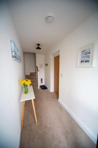 a hallway with a vase of flowers on a table at The Coffee Loft in Padstow
