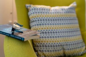 a book with a pair of glasses sitting on top of a pillow at The Coffee Loft in Padstow