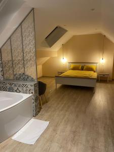 1 dormitorio con cama y bañera en OLGA Chambre D'hôte, en Verdún