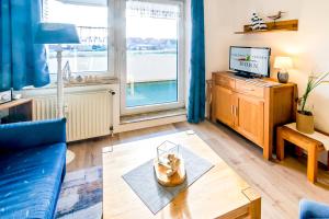 a living room with a blue couch and a tv at Lüttje Nest in Dornumersiel