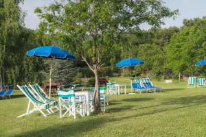 a group of tables and chairs with blue umbrellas at Agriturismo Tripala in Minucciano