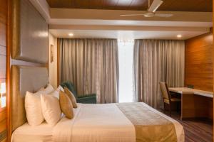 a hotel room with a bed and a desk at Ananth The Grand in Hubli