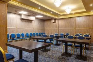 a conference room with tables and blue chairs at Lazur Beach by Stellar Hotels, Adler in Adler