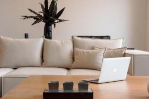 a laptop sitting on a table in front of a couch at Ligaria Mare in Agia Pelagia