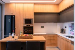a kitchen with wooden cabinets and a table with a basket of fruit at Ligaria Mare in Agia Pelagia