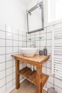 y baño con lavabo blanco y espejo. en Maison Alice /Maison avec vue sur les champs, en Comines