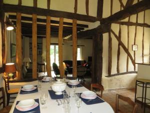 a dining room with a table with plates and glasses at La Ferme de Montboulan in Salbris