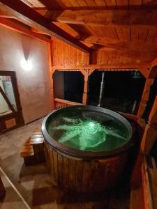 a large wooden tub with green water in a room at Casa OLD BRICK in Ocna Şugatag
