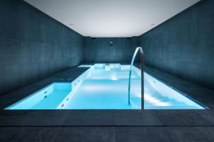 a large swimming pool with a large blue tub at LHP Napoli Palace & SPA in Naples