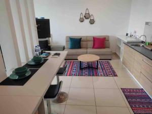 uma cozinha e sala de estar com um sofá e uma mesa em Manis Evo Bangi Soho - pool & netflix & wifi em Bangi