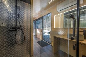 a bathroom with a shower with a glass wall at ROOMBOX Likani in Borjomi