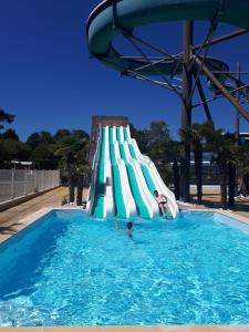 a group of people on a slide in a swimming pool at CAMPING LA PINEDE in Les Mathes