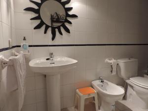 a bathroom with a sink and a toilet and a mirror at Apartamento Barbancho in Cáceres +63 photos