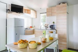 a kitchen with a table with baskets of food on it at CAMPING LA PINEDE in Les Mathes