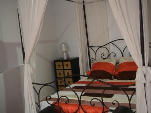 a bedroom with a black iron bed with orange pillows at Apartamento Barbancho in Cáceres