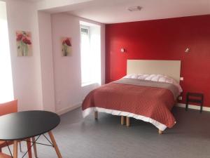 a red bedroom with a bed with a red wall at Les Papoulis in Saint-Laurent-sur-Sèvre