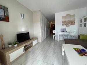 un soggiorno con TV, divano e tavolo di Apartaments Royale Los Cristianos ad Arona