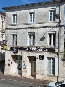 an old stone building with a la versace sign on it at Logis Hôtel La Résidence in Cognac