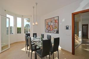 a dining room with a glass table and black chairs at Villa Cactus in Inca
