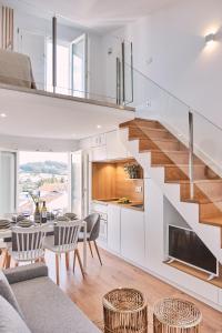 eine Küche und ein Wohnzimmer mit einer Treppe in einem Haus in der Unterkunft ALDARA SUITES in Santiago de Compostela