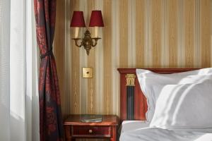 una camera con letto e tavolino con lampada di Gerlóczy Boutique Hotel a Budapest